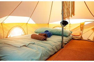 Tienda de campaña llena de colchones hinchables, almohadas y toallas