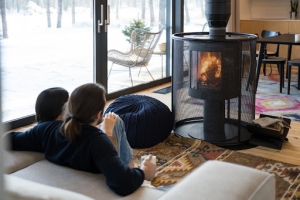 Pareja sentada en el sofá de su casa delante de una estufa