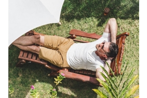 Hombre estirado en una tumbona de jardín