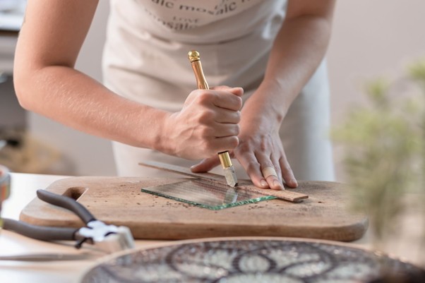 Mujer cortando cristal para una manualidad